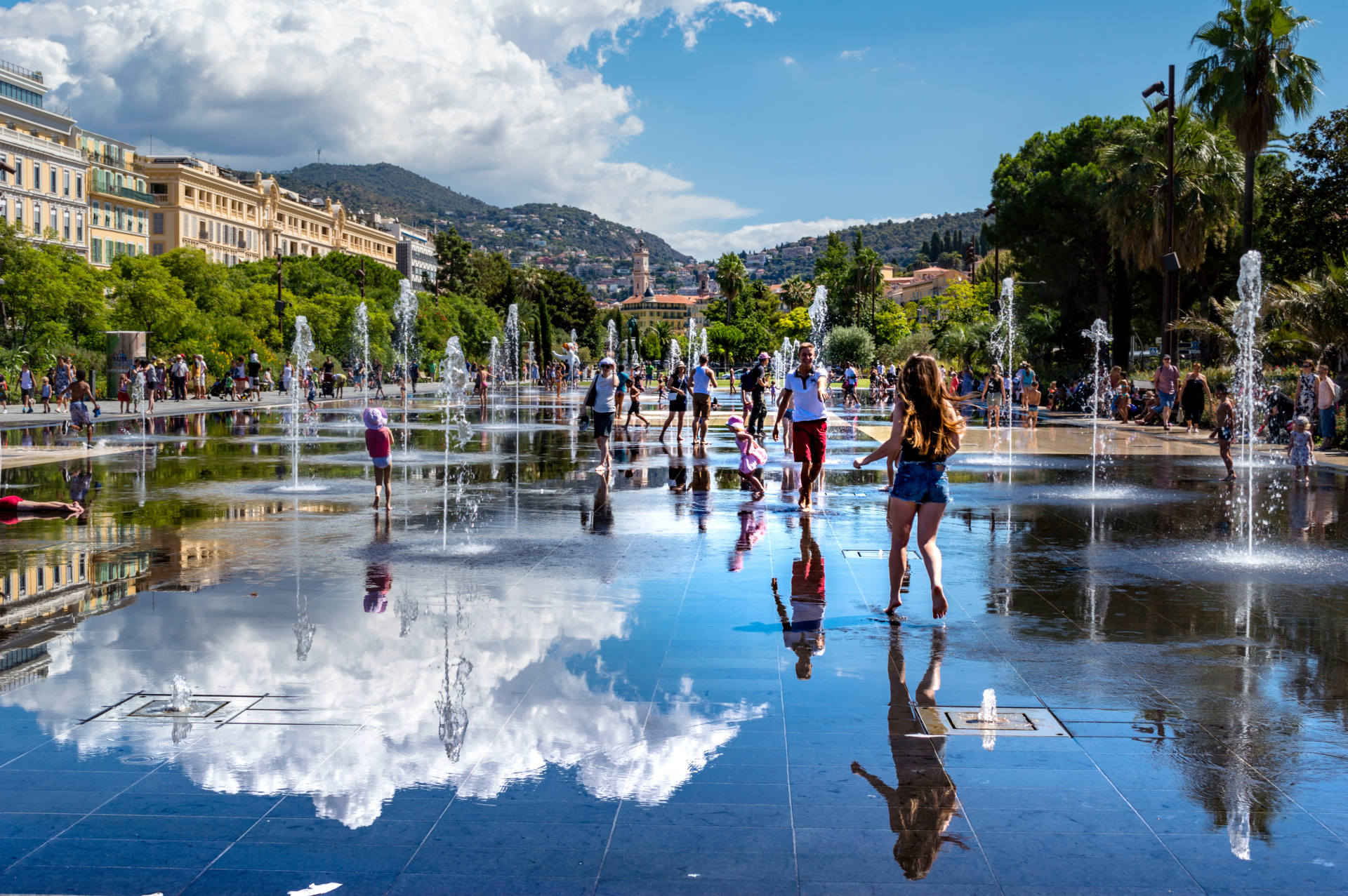 © AdobeStock_194878446 Ein Spazierweg in einem Park im Sommer, 11 Personen gehen dort spazieren. Die Sonne scheint.