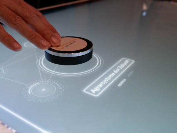 Eine Hand bewegt einen Knopf auf einem digitalen Bildschrim