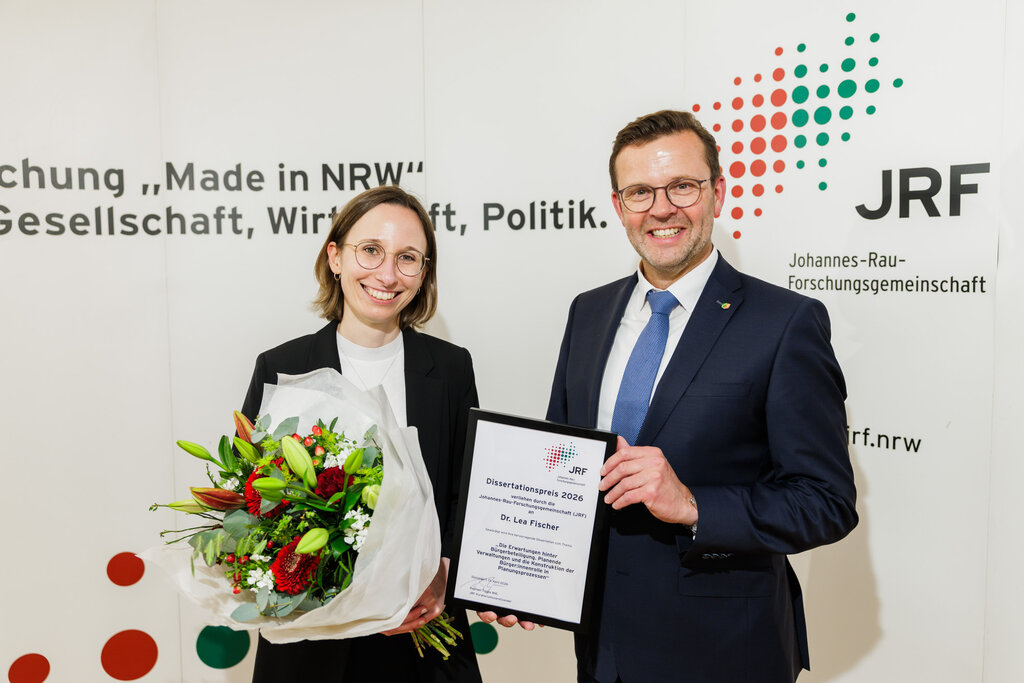 Lea Fischer und Raphael Tigges mit Blumenstrauss und Urkunde
