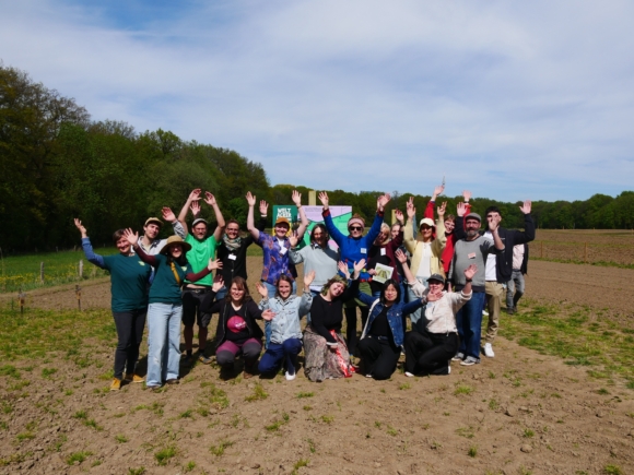 Gruppe aus mehreren Menschen, die sich freuen und fröhlich in die Kamera schauen.
